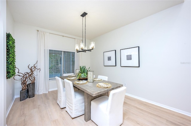 dining space featuring light wood-type flooring and a chandelier