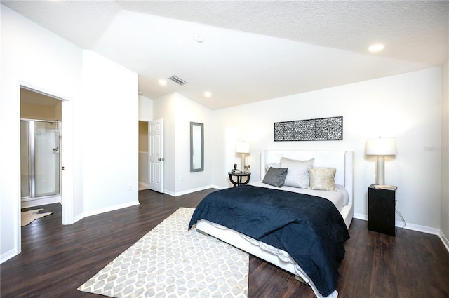 bedroom with vaulted ceiling, a textured ceiling, and dark hardwood / wood-style floors