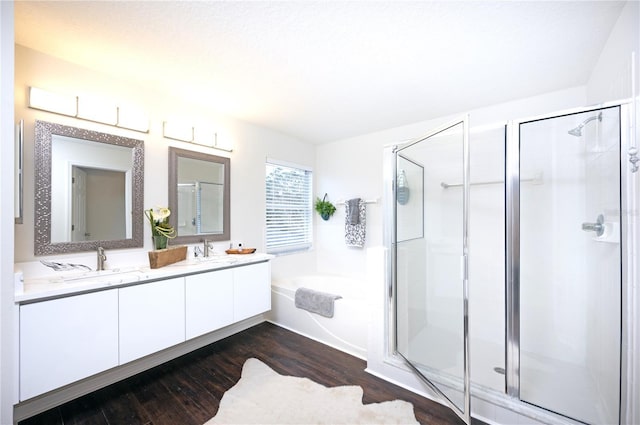 bathroom featuring hardwood / wood-style flooring, vanity, and plus walk in shower