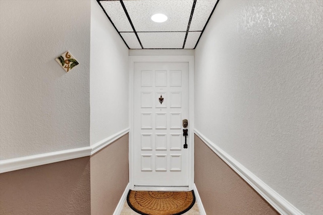 doorway featuring a drop ceiling