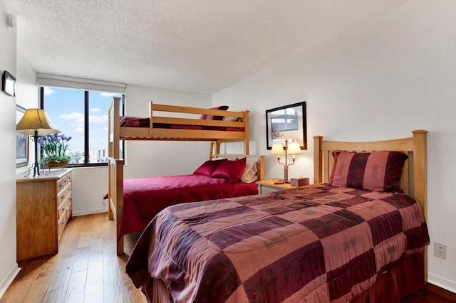 bedroom featuring a textured ceiling and light hardwood / wood-style flooring