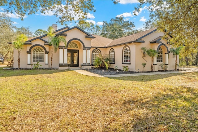 mediterranean / spanish home featuring french doors and a front yard