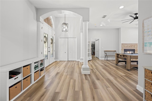 foyer featuring ceiling fan, light hardwood / wood-style floors, and a tiled fireplace