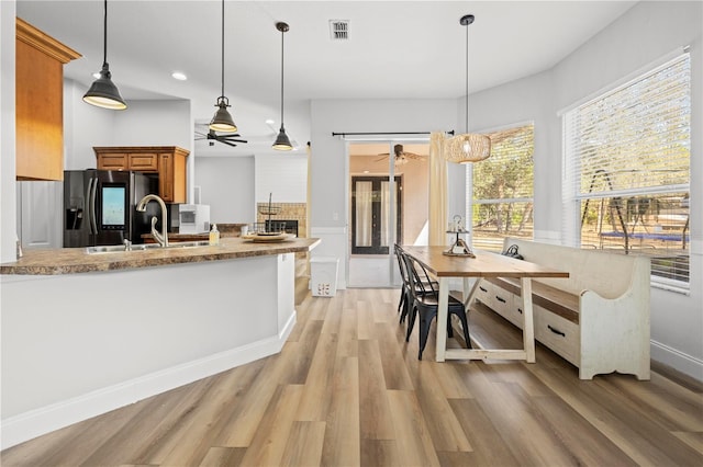 kitchen featuring pendant lighting, light hardwood / wood-style floors, sink, stainless steel fridge, and ceiling fan