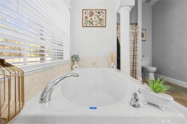 bathroom with a washtub and toilet