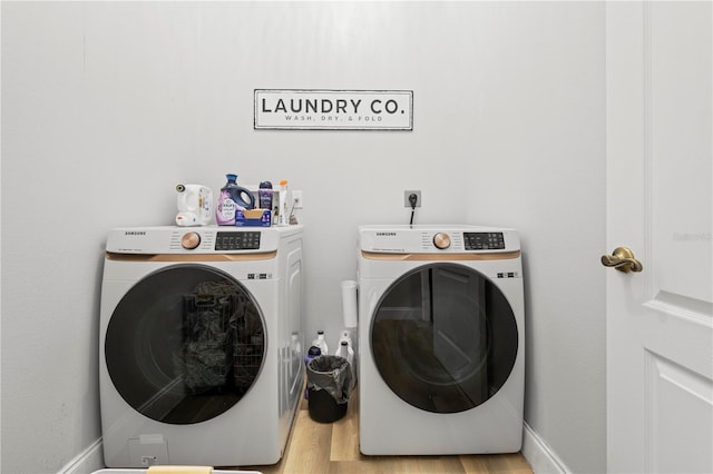 clothes washing area featuring light wood-type flooring and washing machine and dryer