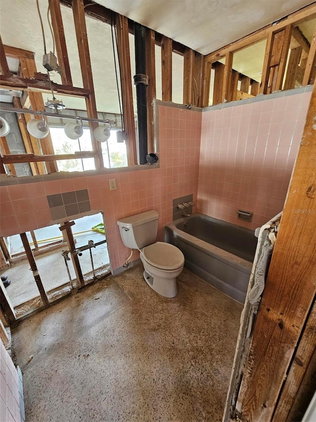 bathroom with toilet, tile walls, and a bathing tub