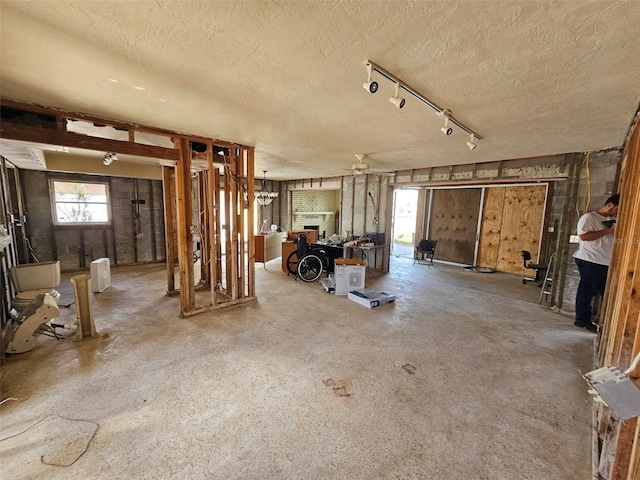 interior space with a textured ceiling and ceiling fan