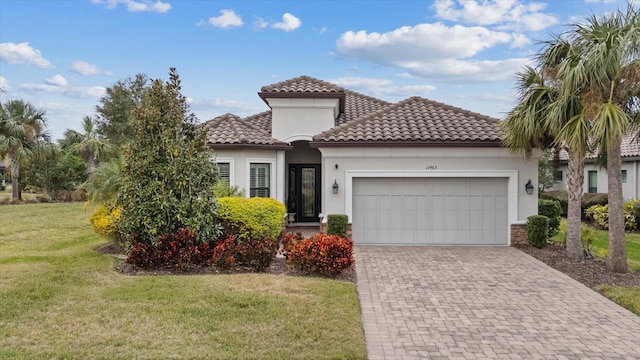 mediterranean / spanish home with a front yard and a garage