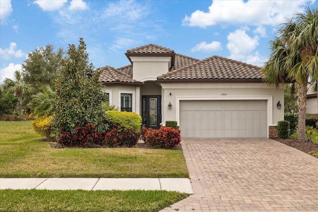 mediterranean / spanish home with a front yard and a garage