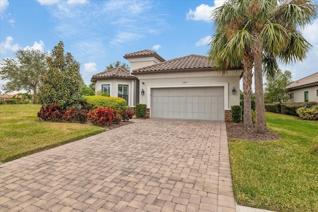 mediterranean / spanish-style home featuring a front lawn and a garage