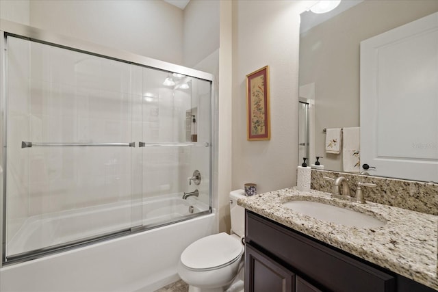 full bathroom featuring vanity, shower / bath combination with glass door, and toilet