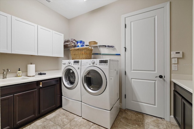 laundry area featuring sink, separate washer and dryer, and cabinets