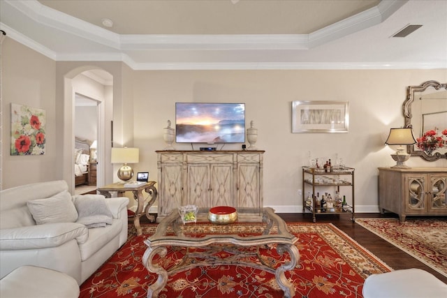 living room with a raised ceiling, ornamental molding, and dark hardwood / wood-style flooring