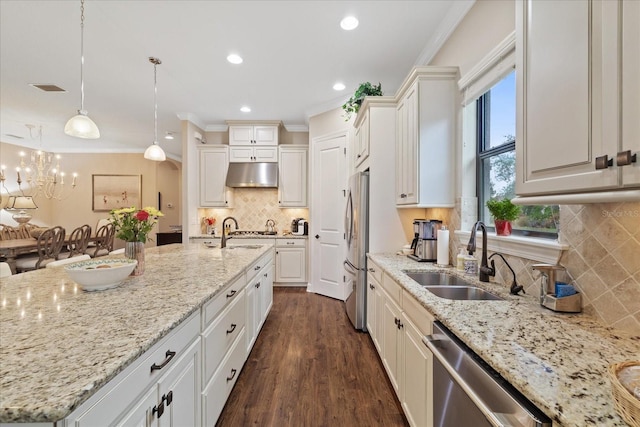 kitchen with sink, stainless steel appliances, white cabinets, and hanging light fixtures