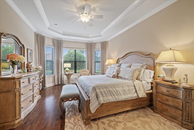 bedroom with ceiling fan, ornamental molding, a raised ceiling, and wood-type flooring