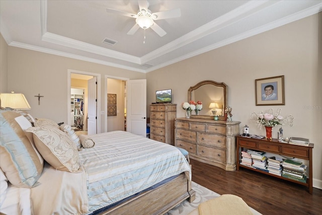 bedroom featuring a raised ceiling, ceiling fan, ornamental molding, and dark wood-type flooring