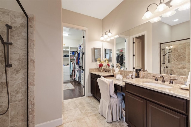 bathroom featuring tiled shower, a chandelier, tile patterned floors, and vanity