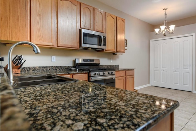 kitchen featuring sink, light brown cabinets, light tile patterned floors, a notable chandelier, and appliances with stainless steel finishes