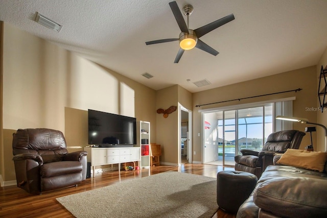 living room featuring a textured ceiling, ceiling fan, and dark hardwood / wood-style floors