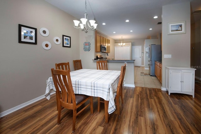 dining space featuring a notable chandelier, dark hardwood / wood-style flooring, and sink