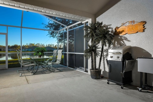 view of patio / terrace featuring a lanai, area for grilling, and a water view