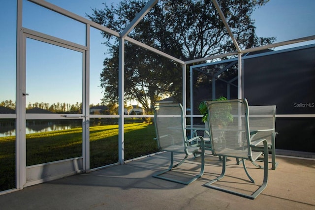 sunroom featuring a water view