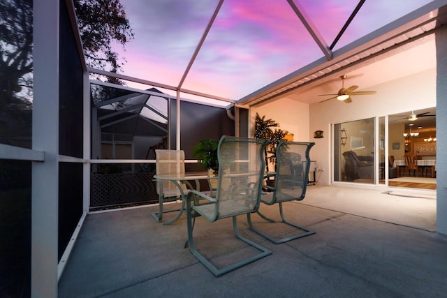 patio terrace at dusk with a lanai and ceiling fan