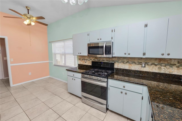 kitchen with appliances with stainless steel finishes, dark stone countertops, decorative backsplash, vaulted ceiling, and ceiling fan