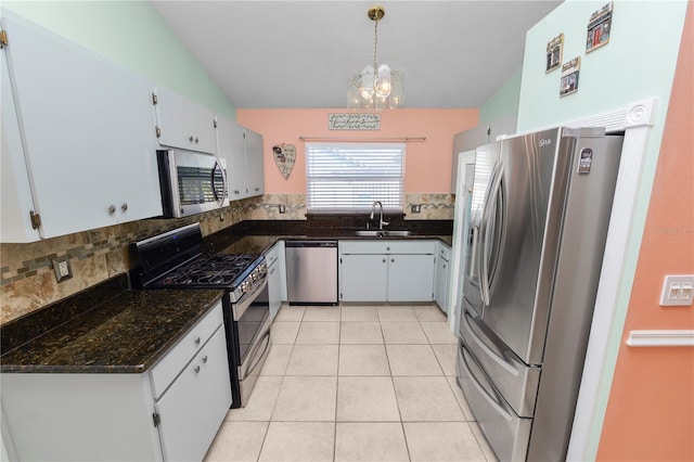 kitchen with backsplash, dark stone countertops, light tile patterned flooring, stainless steel appliances, and a chandelier