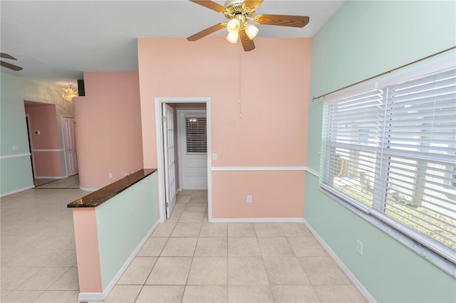 spare room with ceiling fan and light tile patterned floors