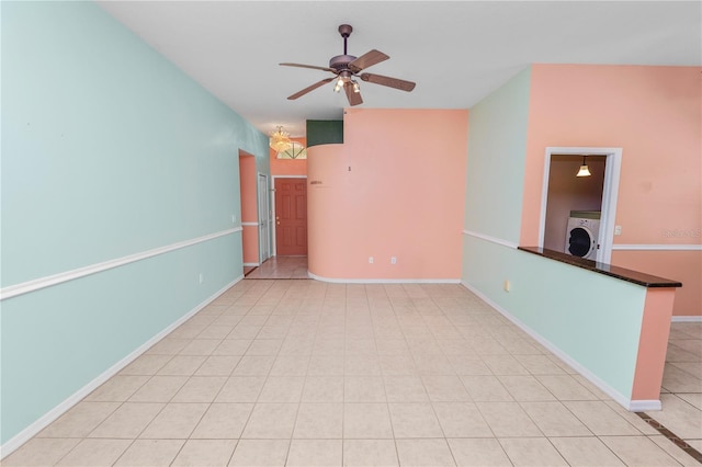 tiled empty room with ceiling fan and washer / dryer