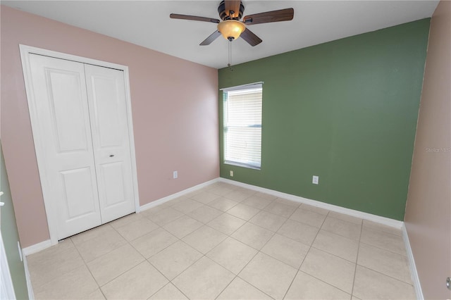 unfurnished bedroom with ceiling fan and a closet