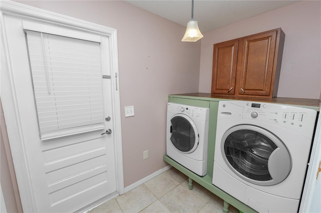 laundry room with cabinets, light tile patterned flooring, and independent washer and dryer