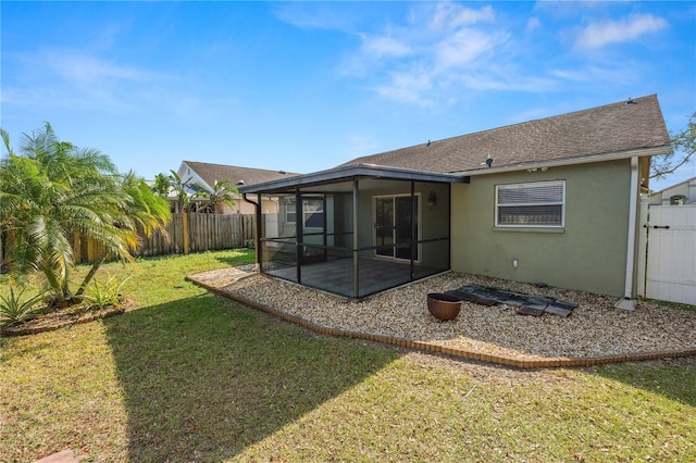 rear view of house featuring a yard and a sunroom