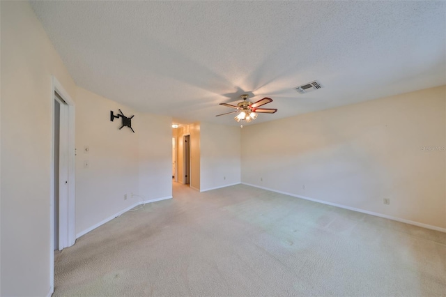 empty room featuring a textured ceiling, ceiling fan, and light carpet