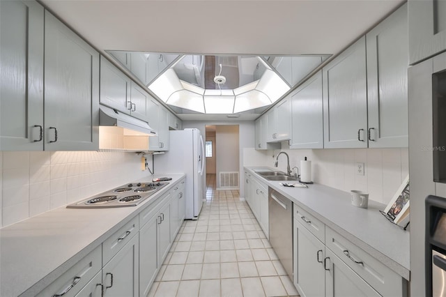 kitchen with backsplash, sink, white appliances, and light tile patterned floors