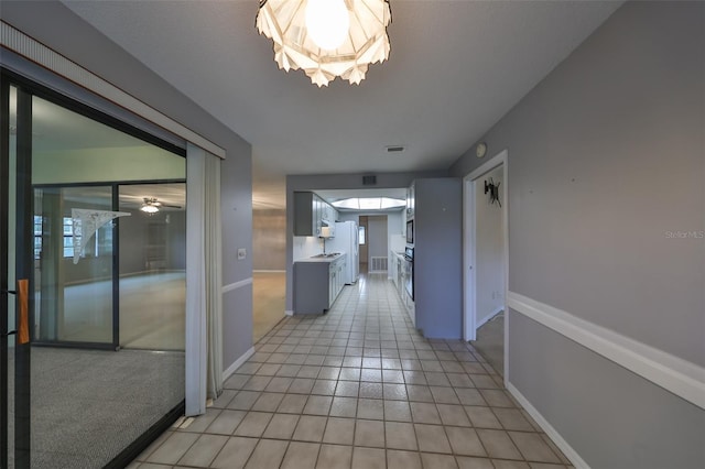 hall with light tile patterned floors