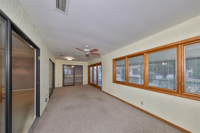 spare room with ceiling fan and carpet