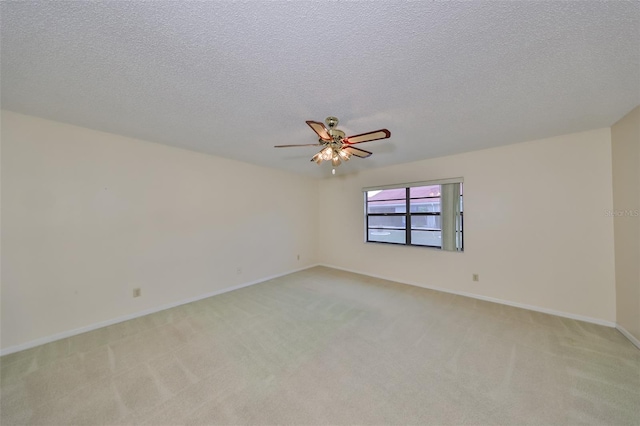 carpeted spare room with ceiling fan and a textured ceiling