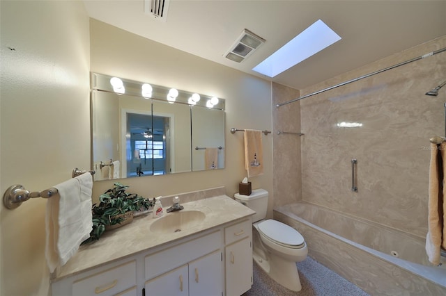 full bathroom featuring tiled shower / bath combo, vanity, a skylight, and toilet