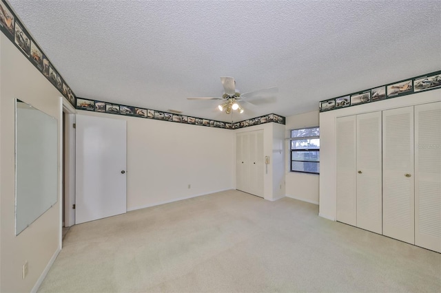 unfurnished bedroom with a textured ceiling, ceiling fan, and light colored carpet