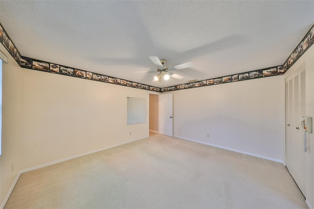 carpeted empty room featuring a textured ceiling and ceiling fan