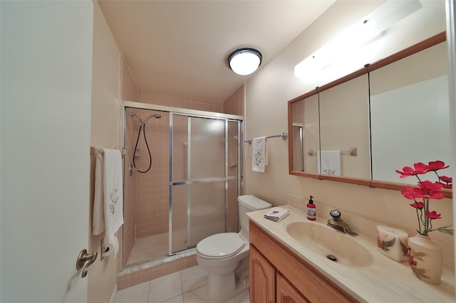 bathroom featuring toilet, a shower with shower door, and vanity