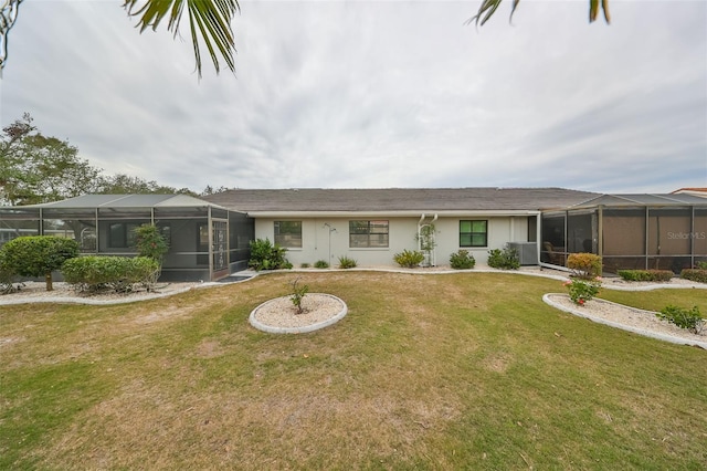 rear view of house featuring glass enclosure, cooling unit, and a lawn