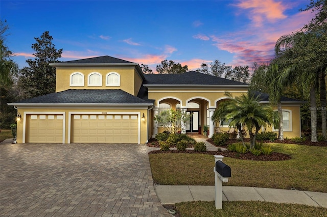 view of front of house featuring a garage and a yard