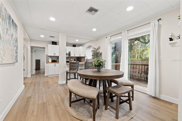 dining area featuring light wood-type flooring and sink