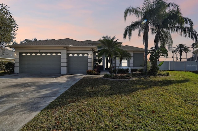 view of front of home with a garage and a yard