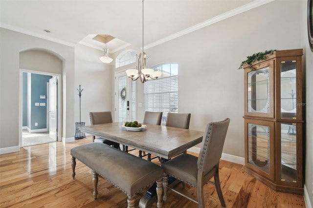 dining room with ornamental molding, light hardwood / wood-style floors, and a chandelier