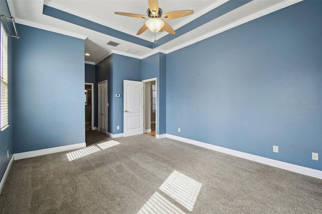 unfurnished bedroom with a raised ceiling, ceiling fan, crown molding, and carpet flooring